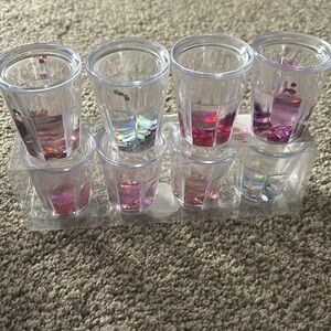 Eight plastic shot glasses with sequin